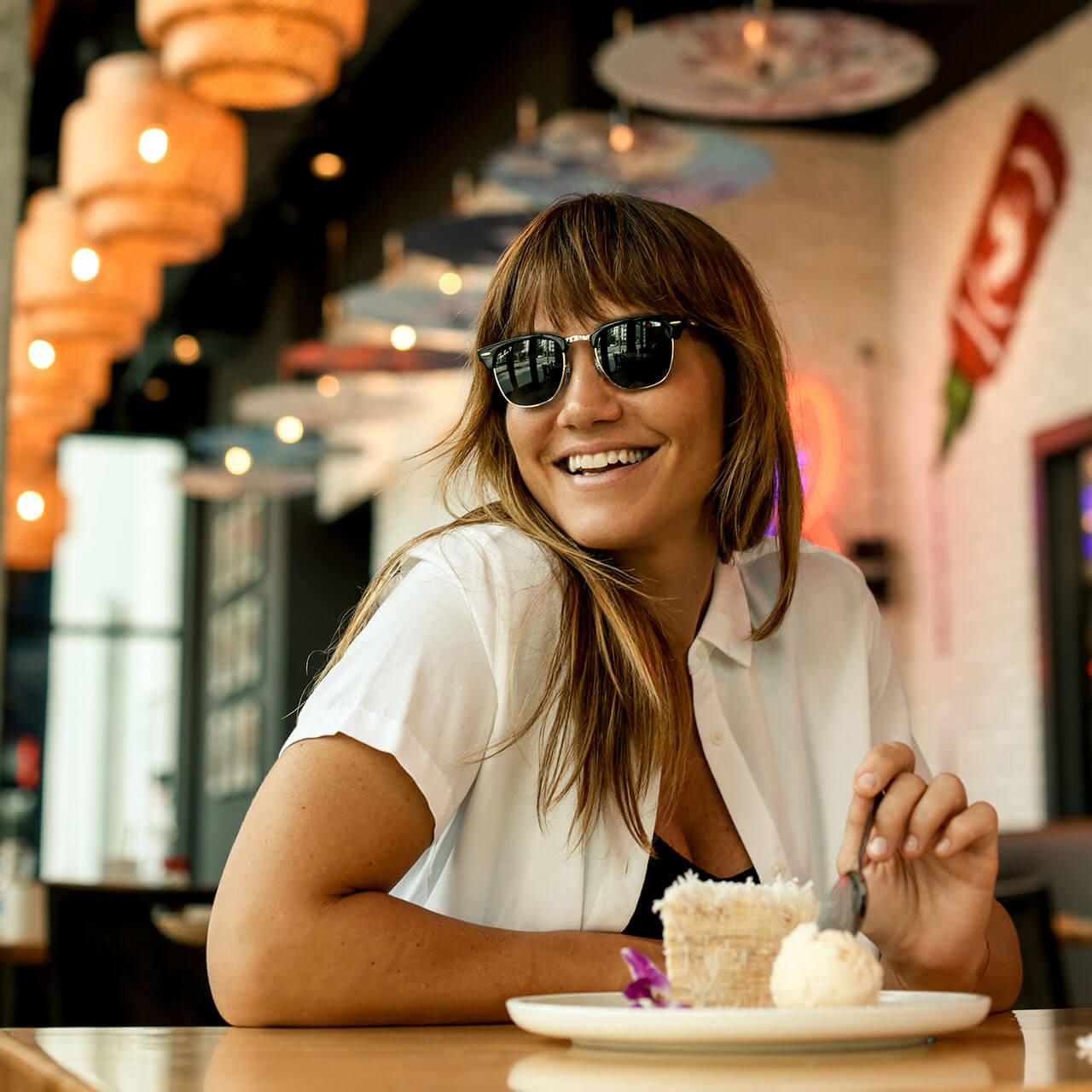 A happy guest enjoying the handmade layered crepe cake with vanilla ice cream at this asian restaurant miami