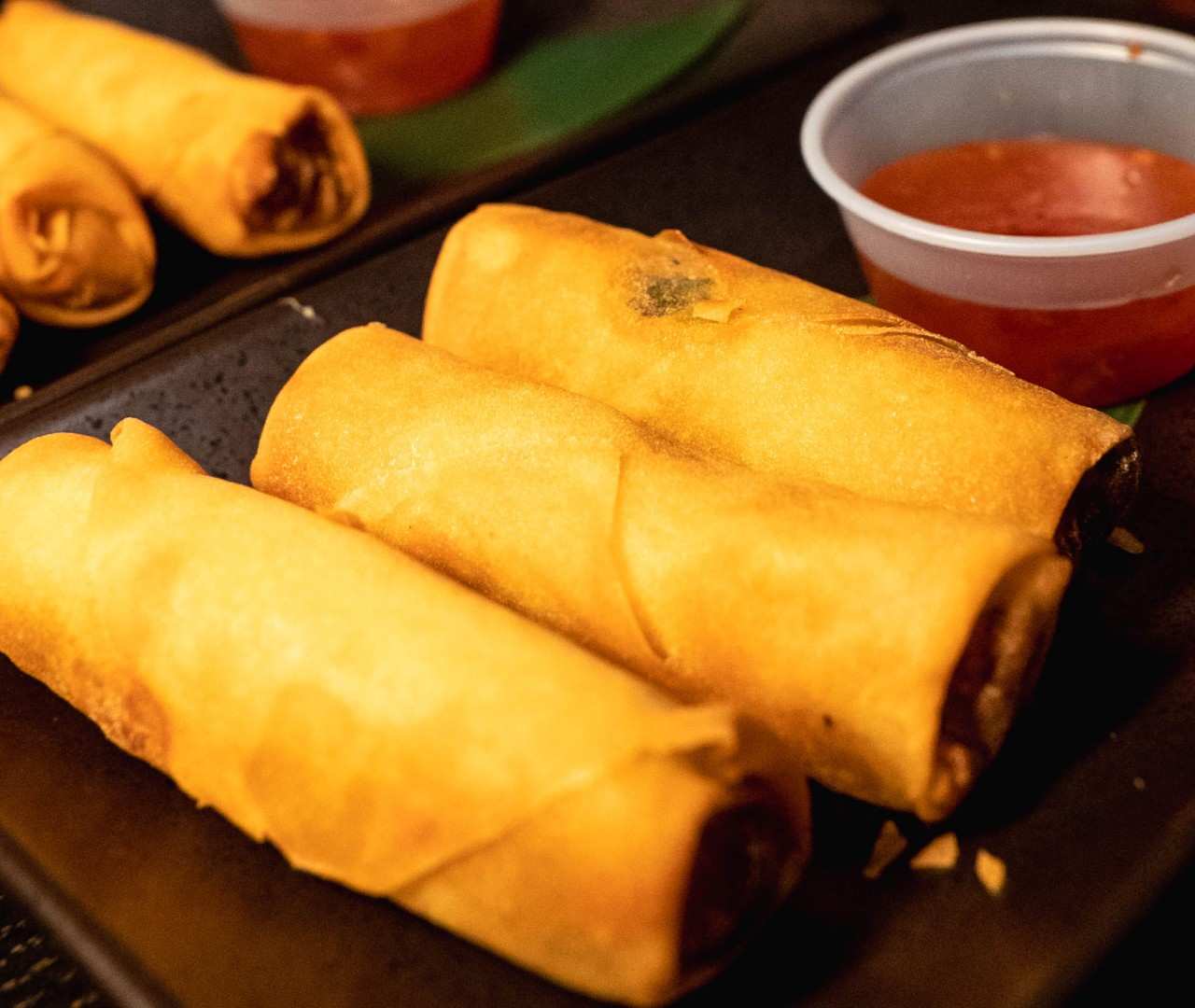 Close-up view highlighting the crispy golden-brown wrapper of fried spring rolls.